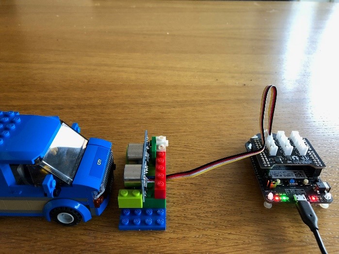 Completed device setup showing Azure Sphere Dev Kit, Ultrasonic Ranger in a LEGO mount and a LEGO vehicle to test the parking system